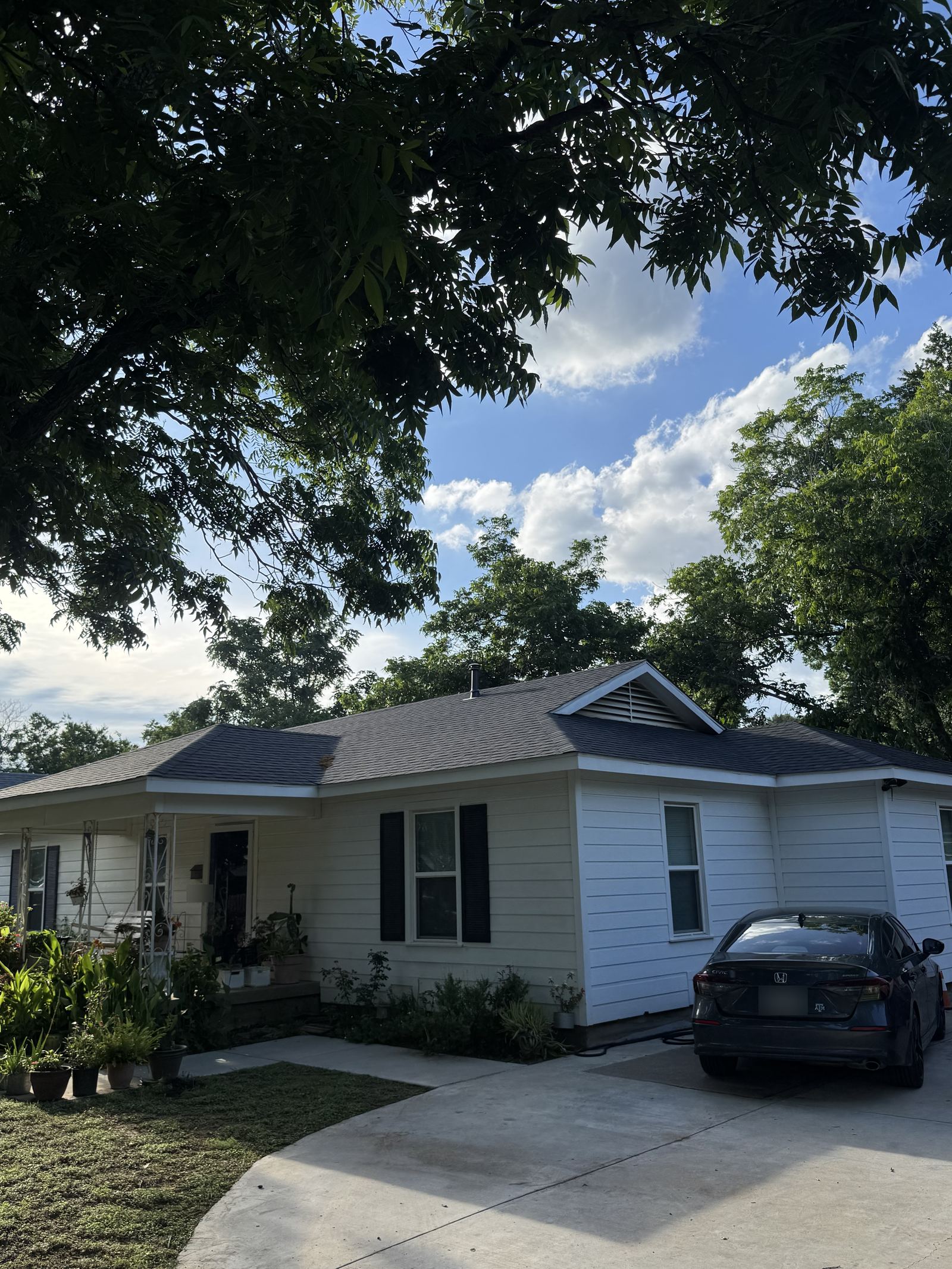 Completed charcoal architectural shingle roof on a single-story home with white siding