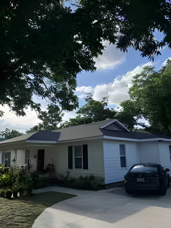 Completed charcoal shingle roof replacement on a single-story home shaded by oak trees